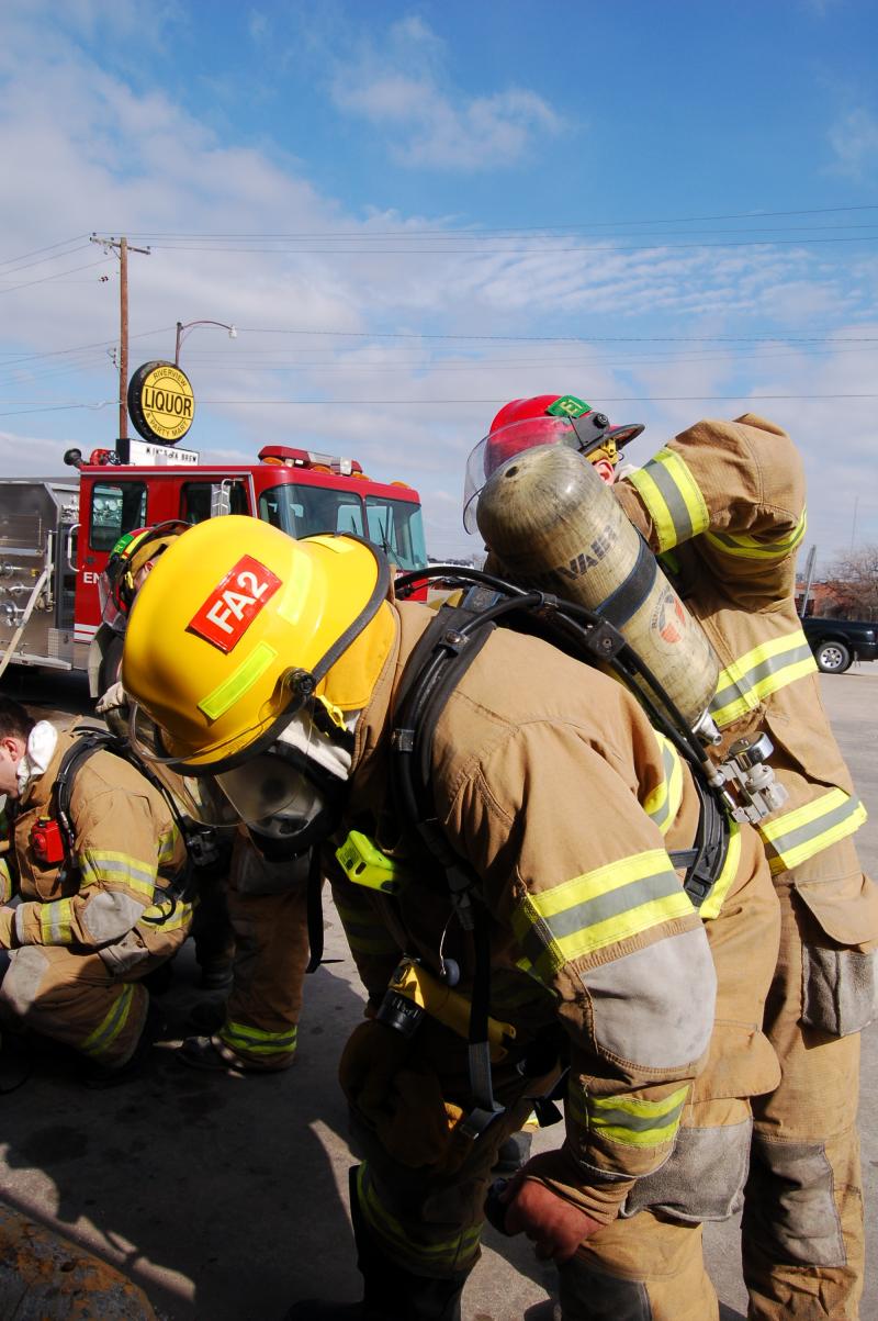 Receiving a fresh air cylinder during forcible entry training
